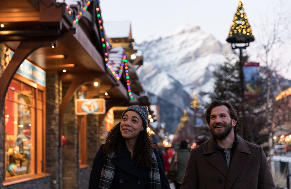Two people walk down Banff Ave doing their Christmas and holiday shopping in Banff and Lake Louise.